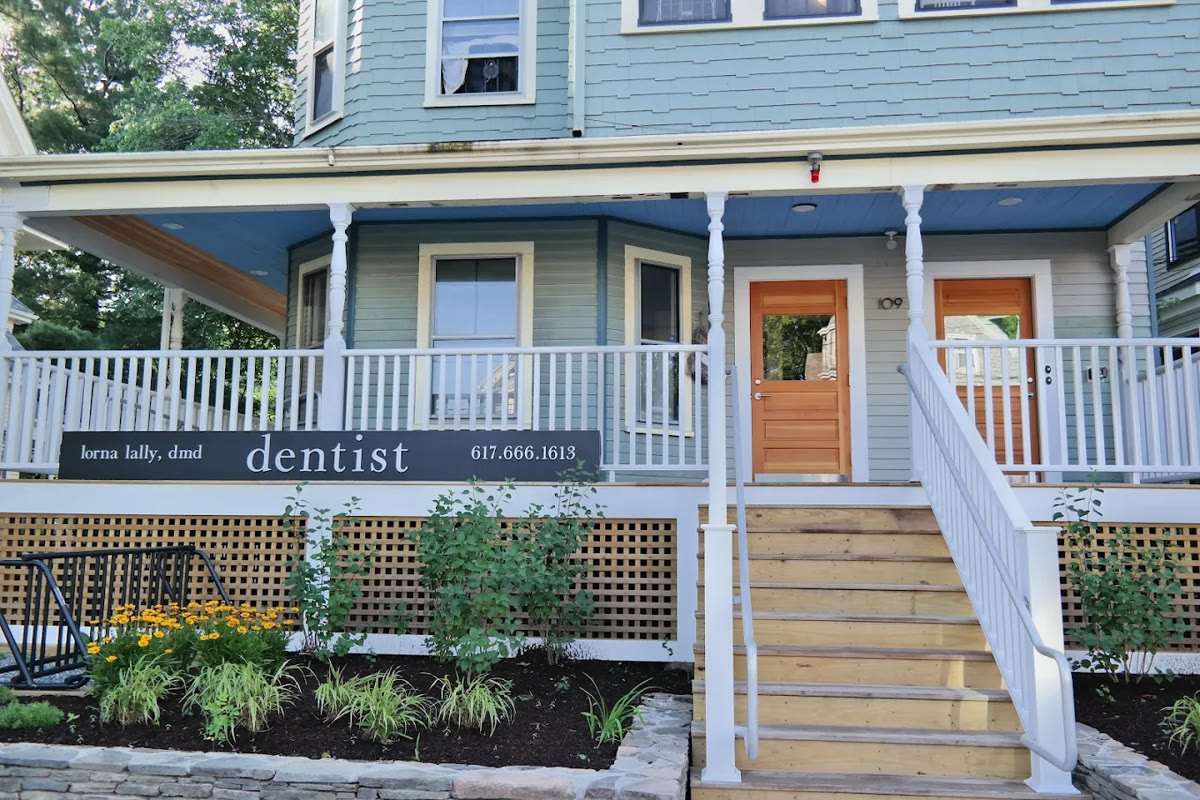 The Somerville office of Lorna Lally, DMD: a light-blue house with a dentist sign and wooden front steps.